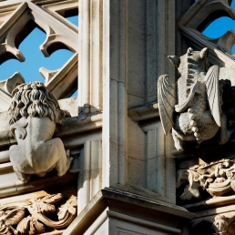 Medieval statues of lion and dragon trying to scale the top of the parapet on Westminster Abbey.